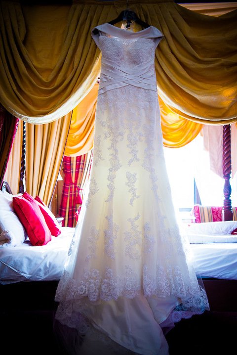 Stanhill Court Wedding Photographer - Wedding dress hanging from four poster bed