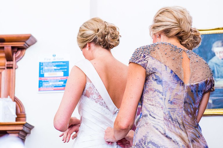Stanhill Court Wedding Photographer - - Mum ties Brides dress