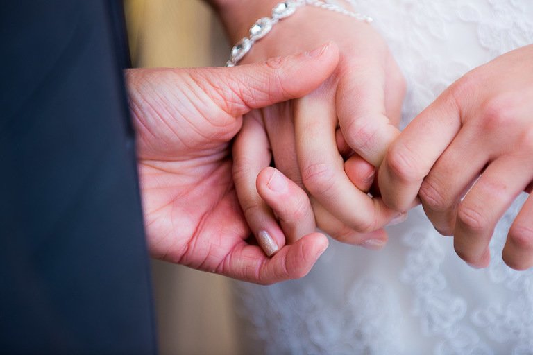 Bride and groom holding hands during ceremony at Stanhill Court