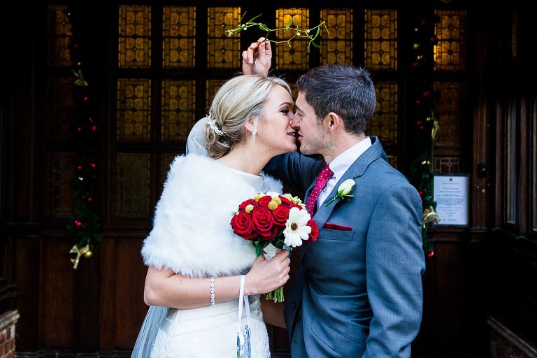 Stanhill Court Wedding Photographer - Bride and groom kiss under the mistletoe