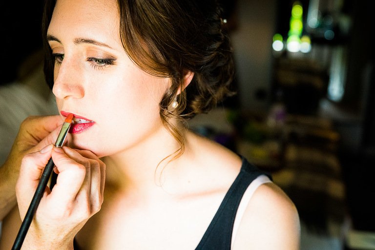 Bride has lipstick applied in The Lodge Hotel in Putney