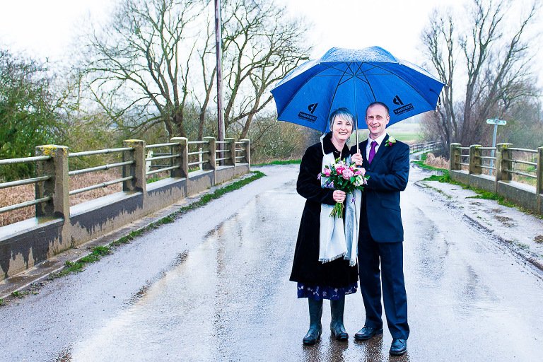Bride and Groom on bridge in the rain