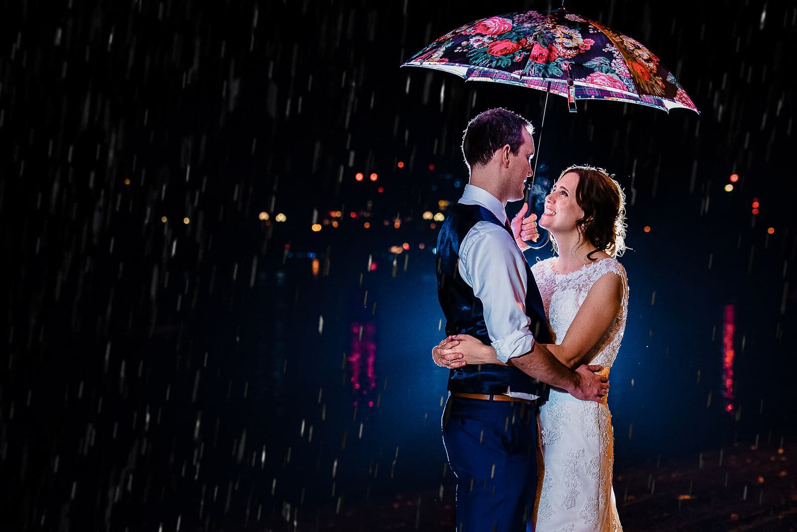 A couple under the umbrella on the banks of the Thames on their wedding day