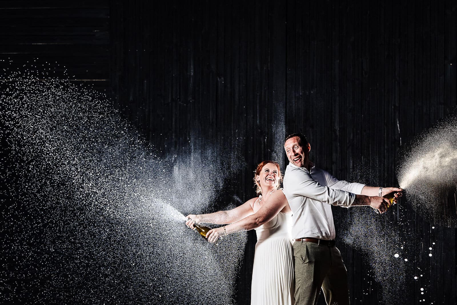 Bride and Groom spray champagne at Hunters Hall