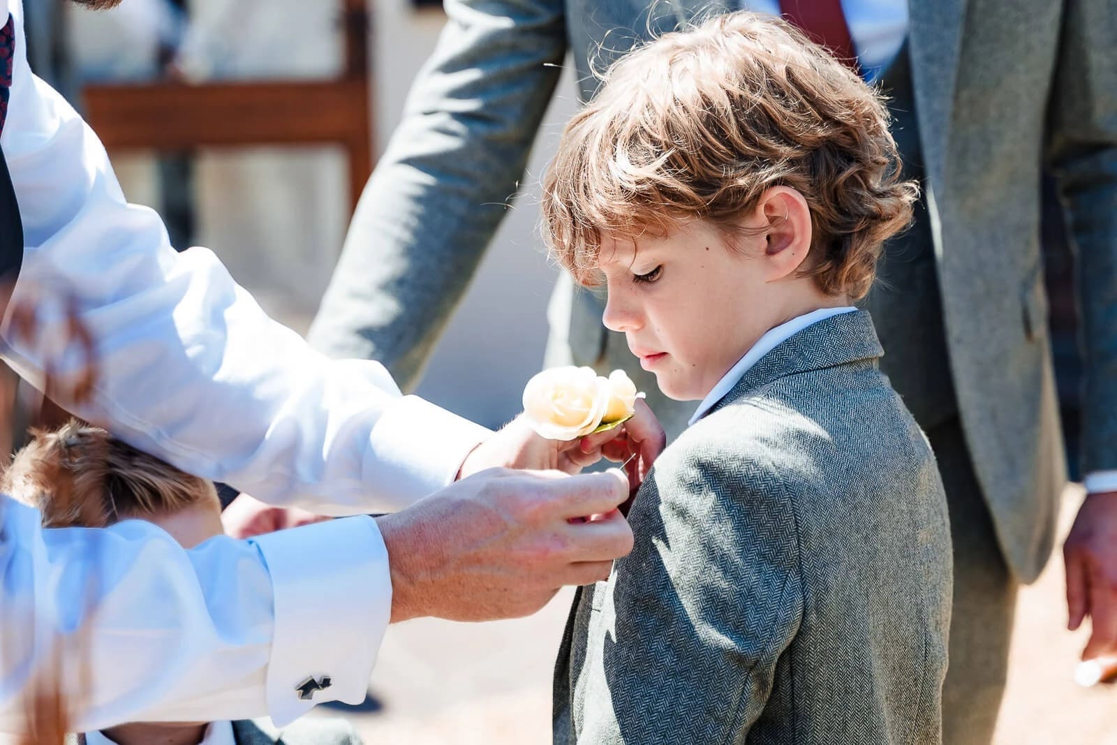 Adult handing food to a young child at an outdoor gathering. — Wedding at Hunters Hall, Norfolk