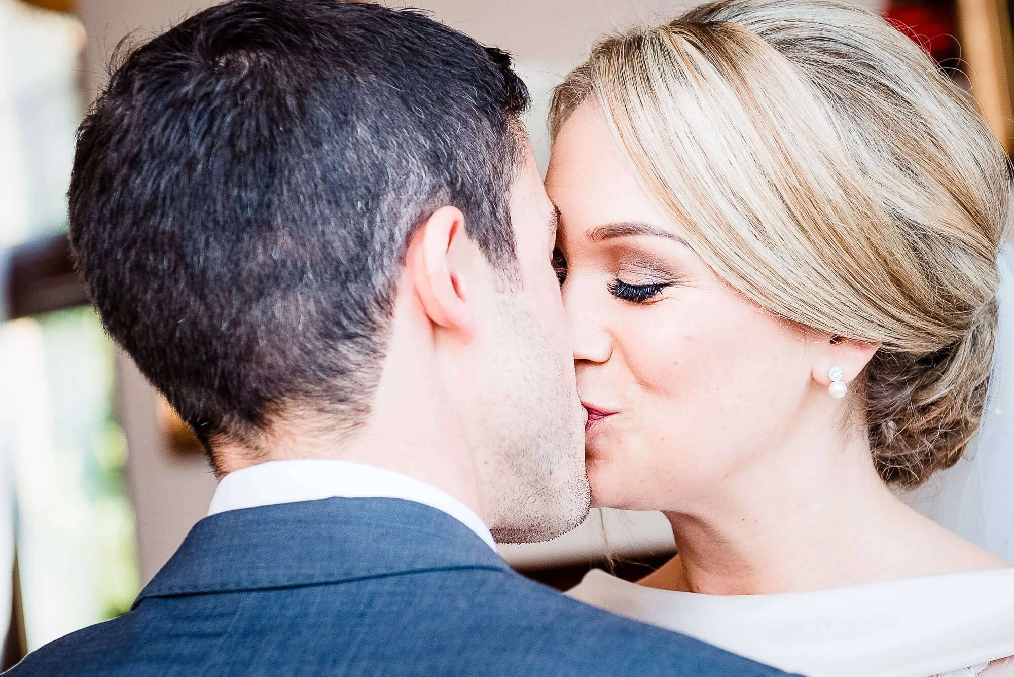 A couple kissing in profile during what appears to be a wedding moment. — Wedding at Stanhill Court Hotel, Surrey