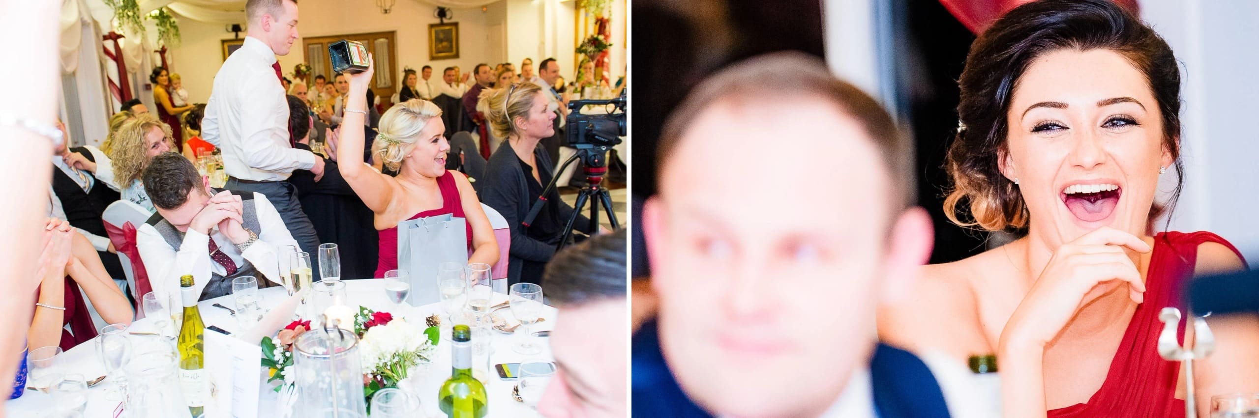 Guests seated at a dinner table during a reception, some standing and applauding or raising glasses in a toast. — Wedding at Stanhill Court Hotel, Surrey