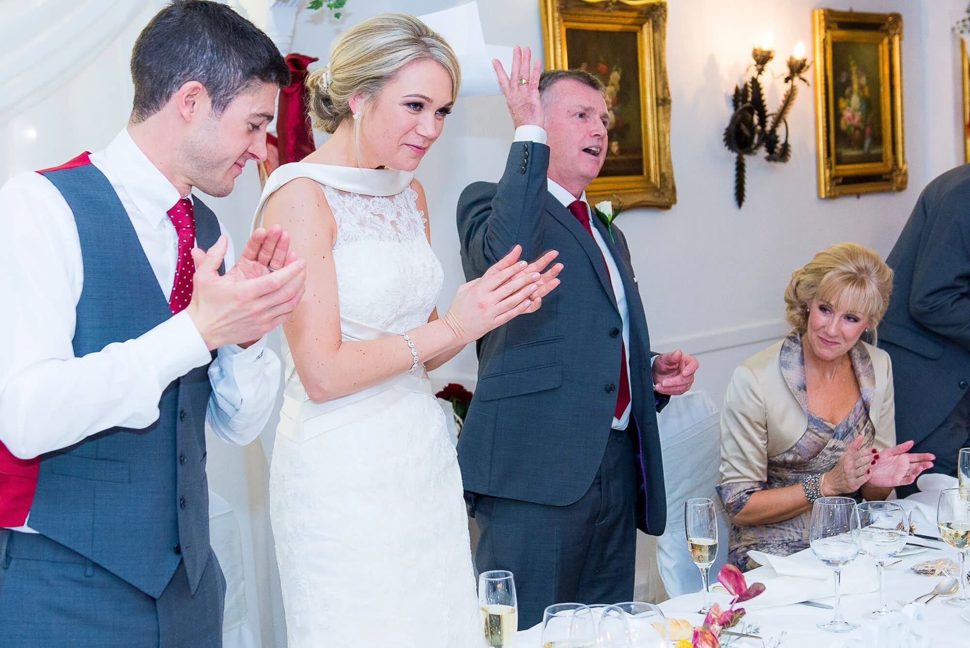 Wedding guests applauding and celebrating during a reception toast or announcement. — Wedding at Stanhill Court Hotel, Surrey