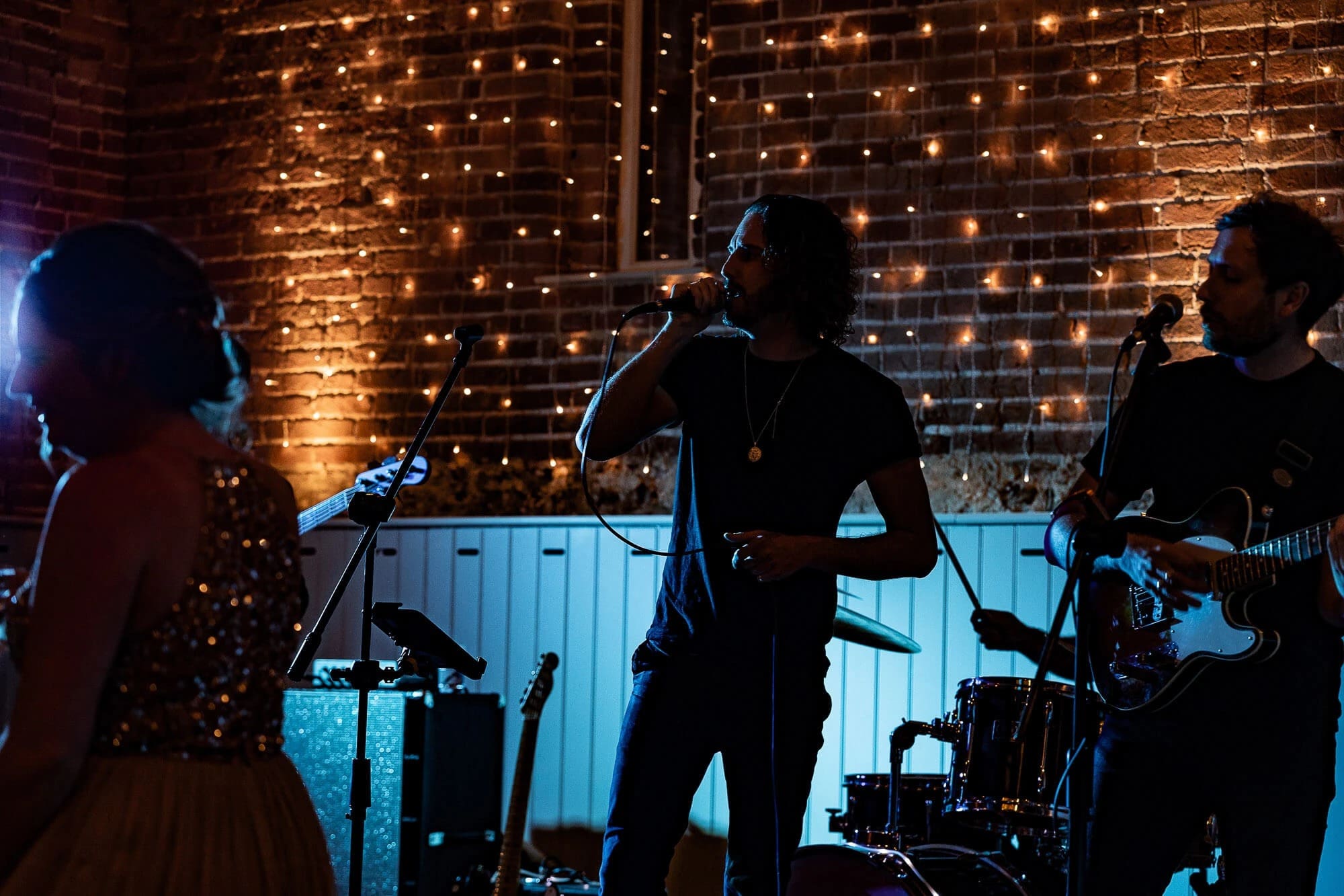 Band performing live on stage with string and wind instruments during an evening concert. — Wedding at Manor Mews, Norfolk