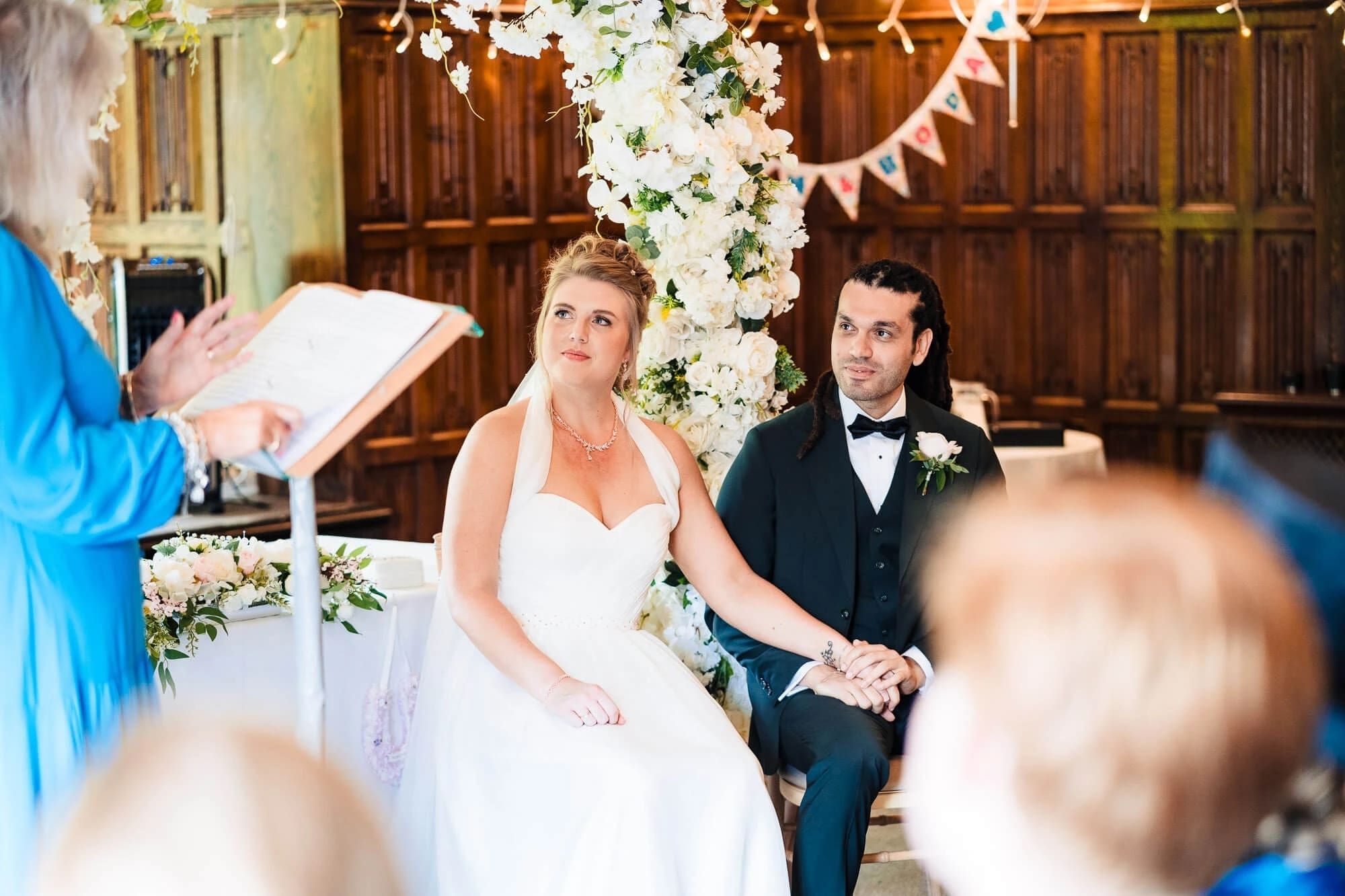 Bride and groom hold hands during their wedding ceremony while an officiant reads vows. — Wedding at Sprowston Manor Hotel, Norfolk