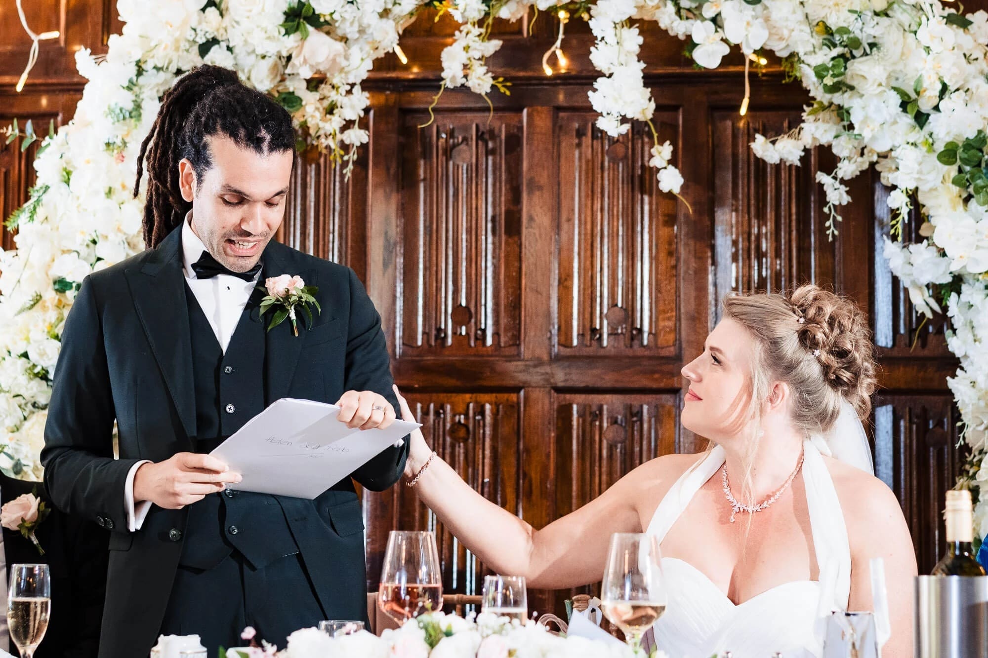 Groom reading vows to bride during reception dinner, bride listening intently. — Wedding at Sprowston Manor Hotel, Norfolk